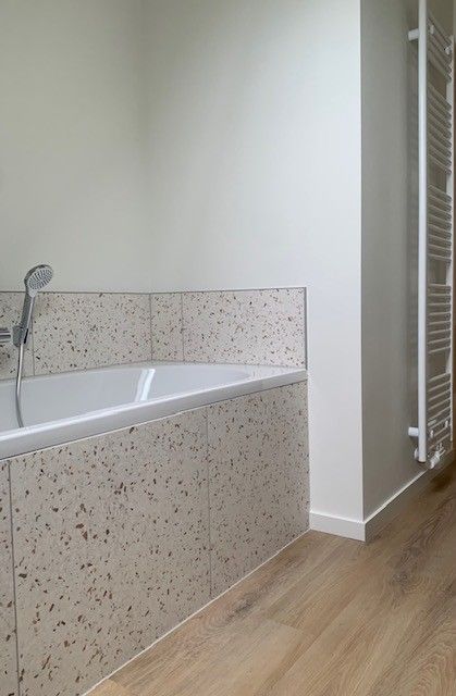 Badkamer met bad en radiator